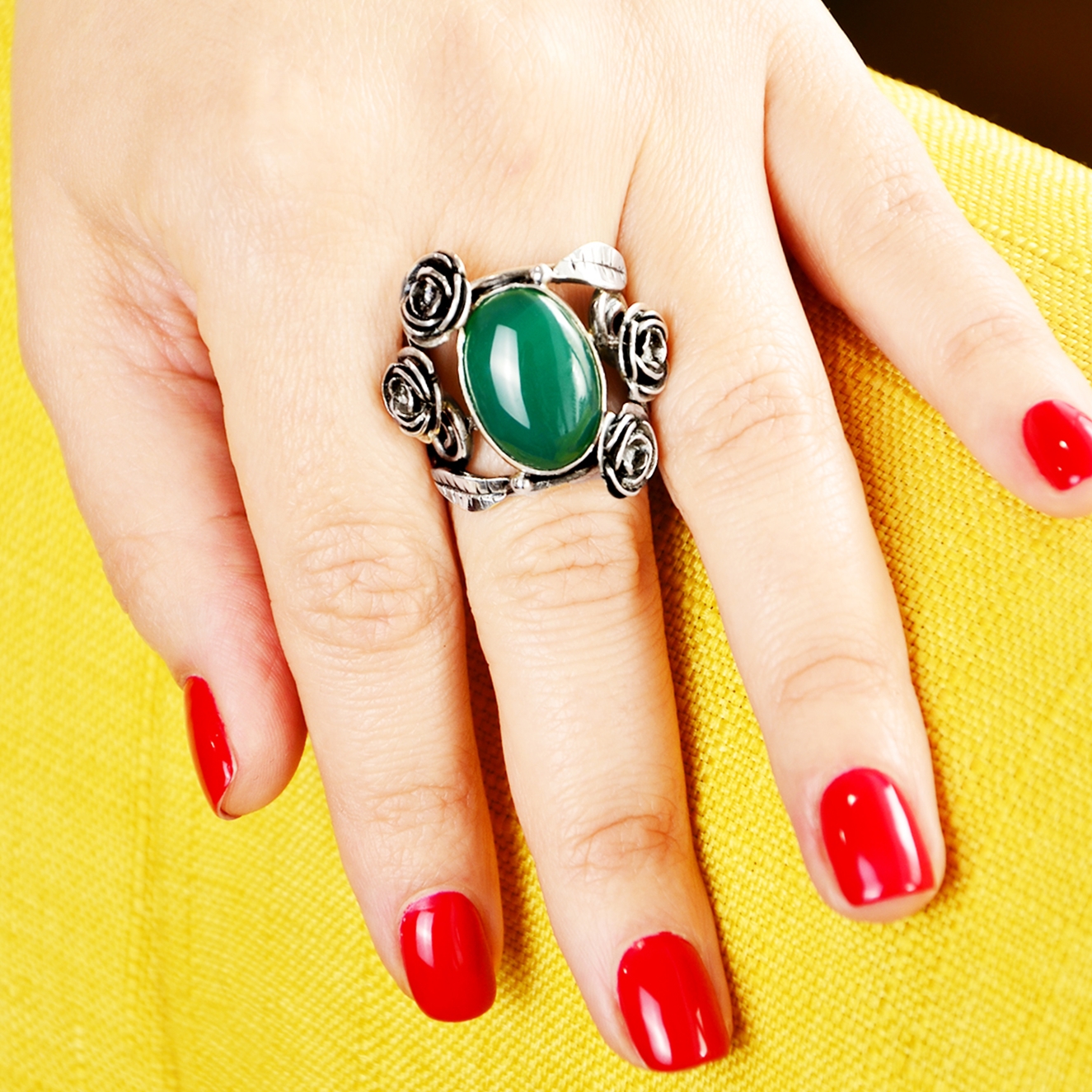 Inel din argint cu flori in jurul cabosonului din agat verde. Una dintre cele mai cunoscute pietre semipretioase. inel pe model.